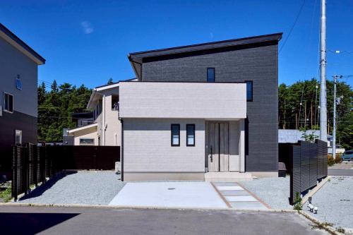 a black and white house with a fence at Fuji no Warabi in Fujikawaguchiko