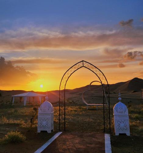 an open gate with the sunset in the background at Sahara dream luxury in Merzouga