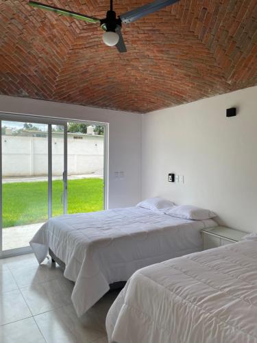a bedroom with two beds and a ceiling fan at Casa Nube in Ixmiquilpan