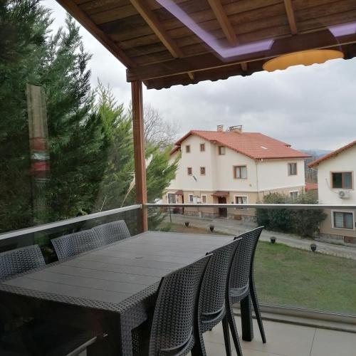 a table and chairs on a balcony with a view of a house at Sultan villaları in Yalova