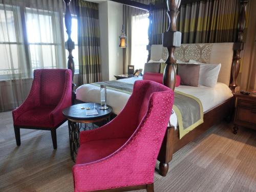 a hotel room with a bed and two chairs at The Birchwood in St Petersburg