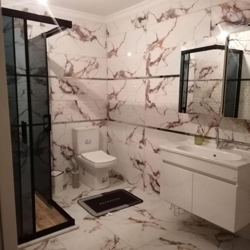a white bathroom with a sink and a toilet at Sultan villaları in Yalova