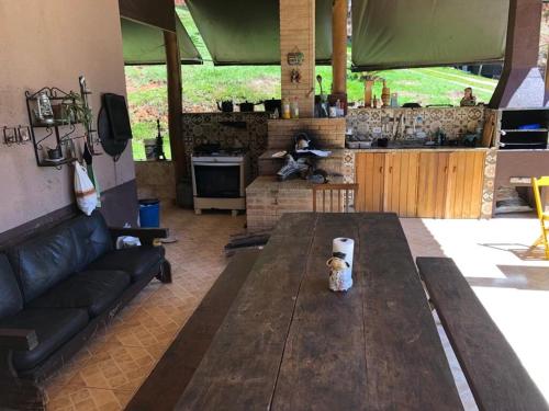 a living room with a wooden table and a kitchen at Rancho Montilla, Great place to replenish energy! in Jambeiro