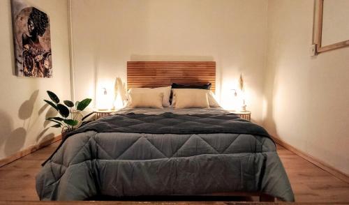 a large bed in a bedroom with two lamps at ORIGEN Centro Monoambiente in El Bolsón