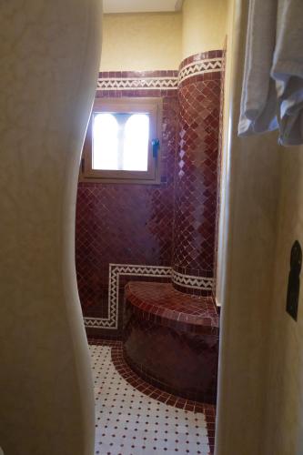 a bathroom with a tub and a window in a room at Palm Dades in Boumalne