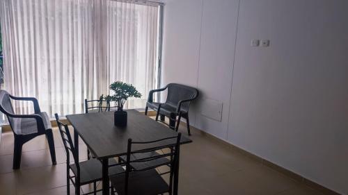 a dining room with a table and chairs and a window at Apartamento Vacacional Carmen de Apicala GursyHost in Carmen de Apicalá