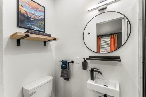 a bathroom with a mirror and a toilet and a sink at Chic and Cozy Stay in Pueblo in Pueblo