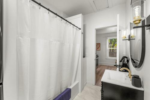 a bathroom with a white shower curtain and a sink at Chic and Cozy Stay in Pueblo in Pueblo