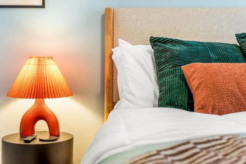 a lamp on a table next to a bed at Chic and Cozy Stay in Pueblo in Pueblo