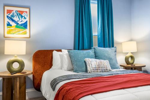 a bedroom with blue curtains and a bed with pillows at Chic and Cozy Stay in Pueblo in Pueblo