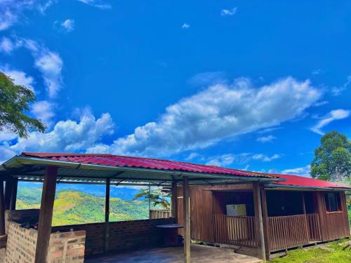 a building with a red roof with a view at Cabaña Mirador Cafetero in Zetaquira