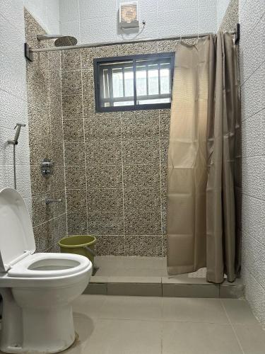 a bathroom with a toilet and a shower at ILHAM SUITEs in Abuja