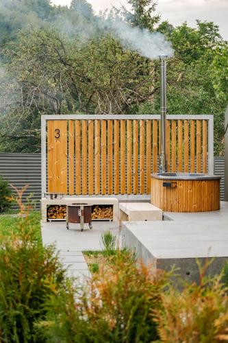 a wooden deck with a grill with smoke coming out at Uphill Spa Chalets in Bran