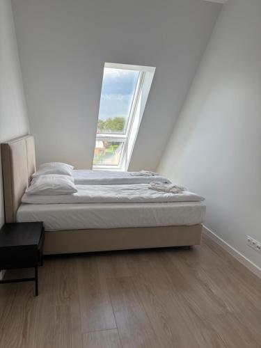 a bed in a room with a window at Czarna Perła Hel in Hel