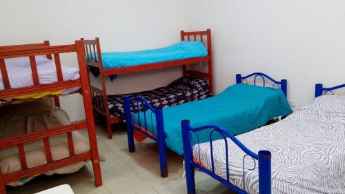 a room with three bunk beds in a room at Pequeño Complejo Pachamama - Casa Sol in San Antonio