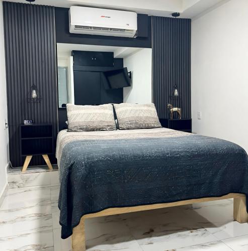 a bedroom with a bed with a blue comforter at La Puerta Blanca #2 in Puerto Vallarta
