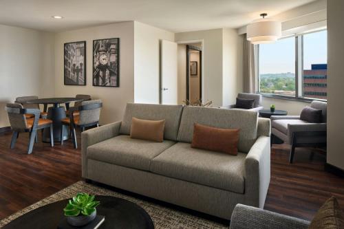 a living room with a couch and a table at Sheraton Suites Chicago O'Hare in Rosemont