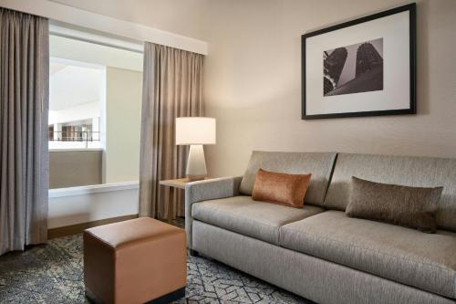 a living room with a couch and a window at Sheraton Suites Chicago O'Hare in Rosemont
