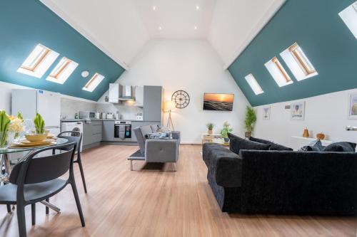 a living room with couches and a dining room at Belgrave Chapel - Luxurious Apartment in Darwen