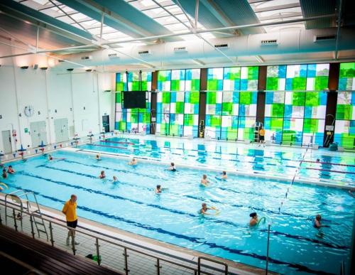 a large swimming pool with many people in it at Belgrave Chapel - Luxurious Apartment in Darwen