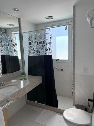 a bathroom with a shower and a sink and a mirror at Flat Golden Macaé vista mar in Macaé