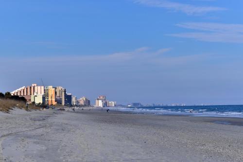a beach with buildings in the background and the ocean at Cabana Shores Hotel in Myrtle Beach