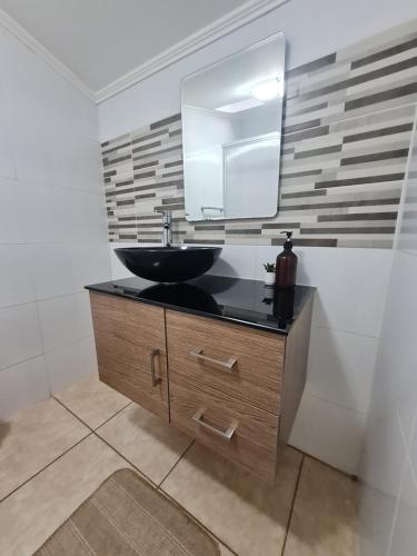 a bathroom with a sink and a mirror at Nido Del Bosque in Pucón
