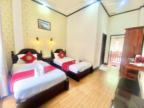 Ένα ή περισσότερα κρεβάτια σε δωμάτιο στο Luang Prabang Pavilion Hotel & Travel