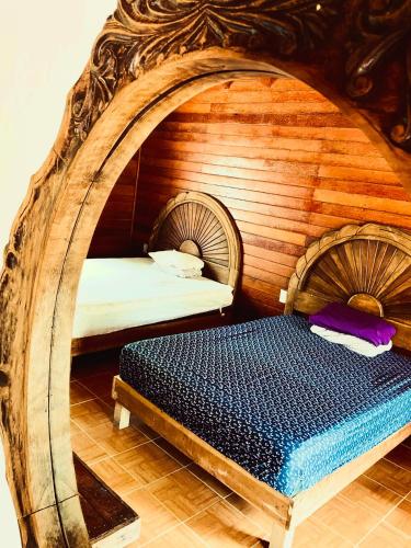 a bedroom with a bed in a wooden room at Los Fundadores Estancia Ecológica in Comalcalco