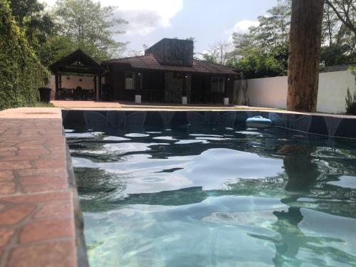 a pool of water with a house in the background at Los Fundadores Estancia Ecológica in Comalcalco