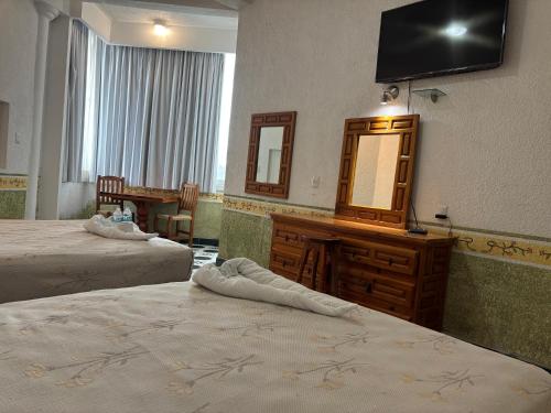 Una televisión o centro de entretenimiento en Hotel Fiesta Palmar