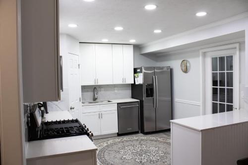 a kitchen with white cabinets and a stainless steel refrigerator at Lovely 3-Bedroom Duplex in Douglasville