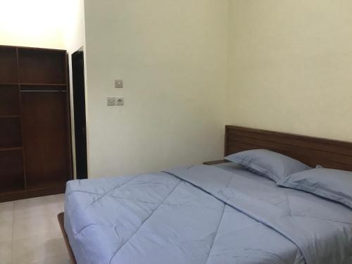 a bedroom with a bed with blue sheets at Lahar Villa Lombok in Masbagik