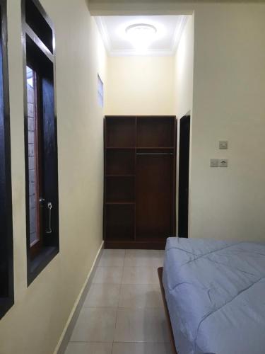 a bedroom with a bed and a closet and a door at Lahar Villa Lombok in Masbagik