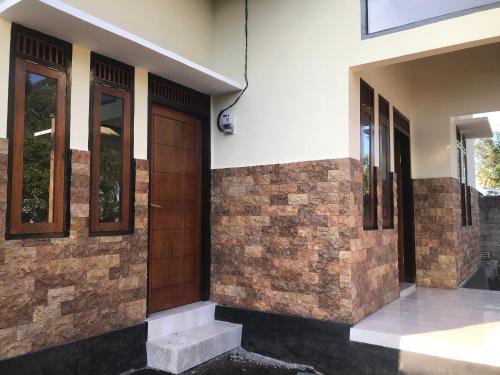 a house with a wooden door and windows at Lahar Villa Lombok in Masbagik