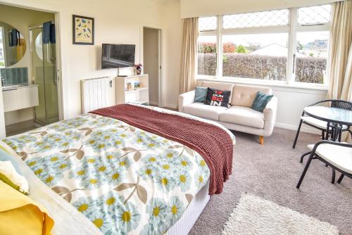 a bedroom with a bed and a couch at Sunny Mornington 2 Bedroom Guest Suite in Dunedin