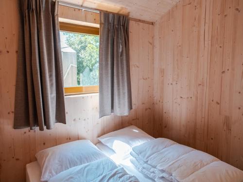 ScherpenzeelにあるHoliday home in Scherpenzeelの枕が2つと窓とベッドがある寝室