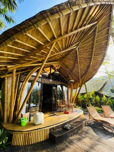 a large wooden roof on a house with a deck at Trivana Sanctuary by Arcada Bali in Sidemen