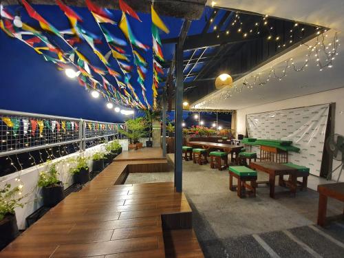 a restaurant with tables and benches and flags on the ceiling at Teofel Hostel by Hiverooms in Sampong