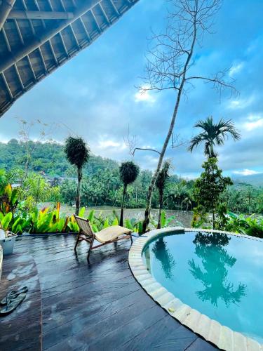 a swimming pool at a resort with trees in the background at Trivana Sanctuary by Arcada Bali in Sidemen