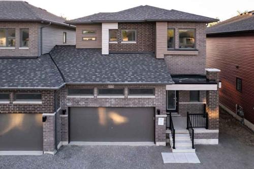 a house with two garage doors and a roof at Tranquil Lakeside Townhouse in Severn
