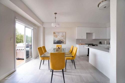a kitchen and dining room with a table and yellow chairs at Tranquil Lakeside Townhouse in Severn
