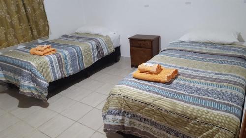 Dos camas una al lado de la otra en una habitación. en Belen, en Ushuaia
