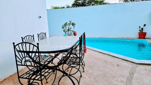 a table and chairs next to a swimming pool at Villa with pool, close to sea in Warang