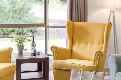 a living room with a yellow chair and a table at Mollymook Memories - close to beach & golf course in Mollymook
