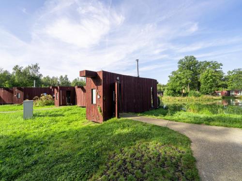 a small wooden building on a field with a road at Comfort & Nature Bungalow in Antoing