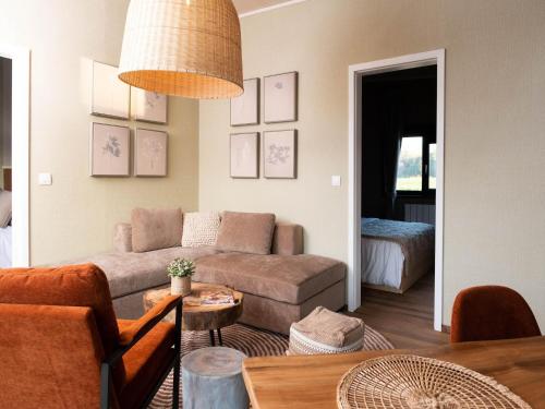 a living room with a couch and a table at Comfort & Nature Bungalow in Antoing