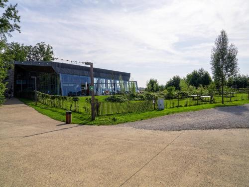 a building with a fence next to a dirt road at Comfort & Nature Bungalow in Antoing