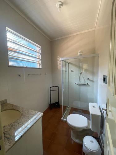 a bathroom with a toilet and a glass shower at Casarão Cidade Imperial in Petrópolis