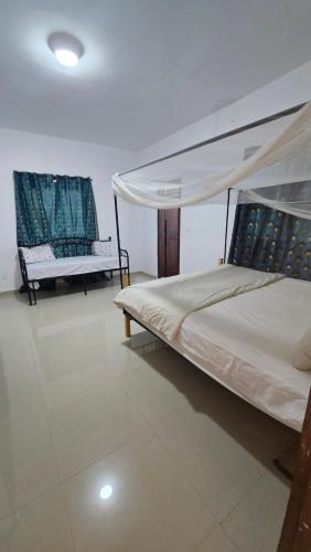 a bedroom with a canopy bed and two chairs at Villa with pool, close to sea in Warang